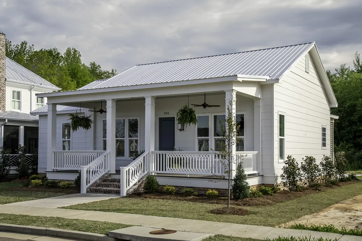 Front exterior of a house with white siding, gray roof, porch, and landscaping.