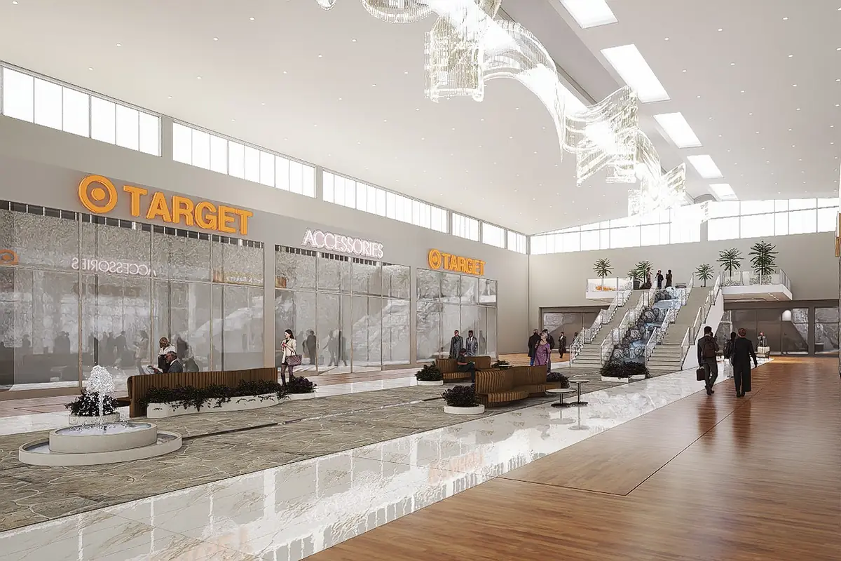 Open retail space with glass storefronts, benches, a staircase, fountain, and skylights for natural light