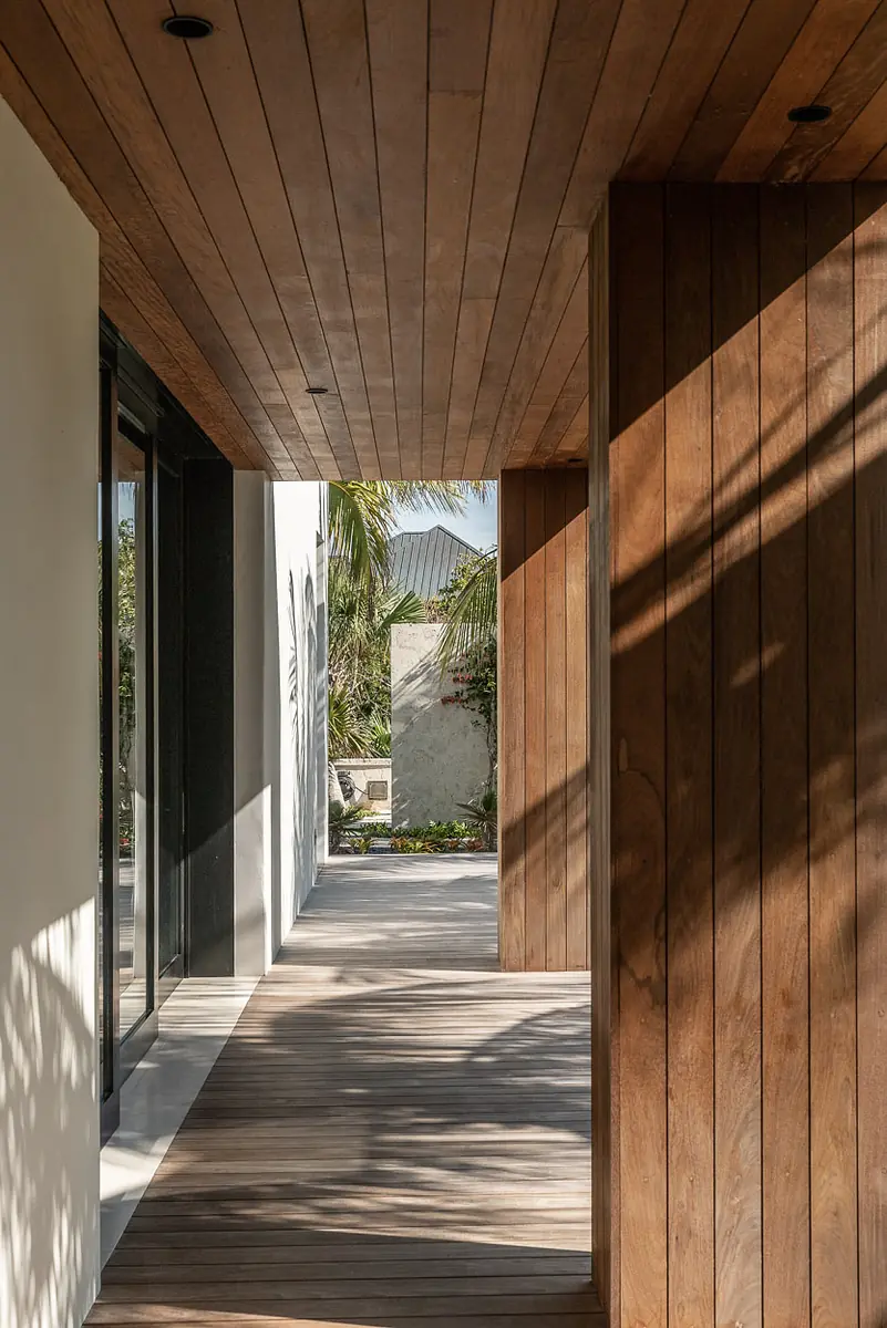 Hallway with wooden ceiling and walls, large glass doors, and wooden decking.