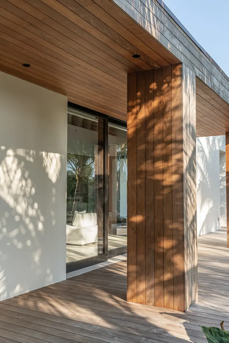 Exterior front view with wooden column, glass window, and wooden deck.
