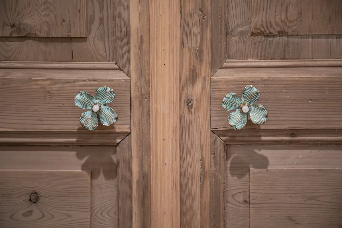 Close-up of decorative wooden doors with flower-shaped handles.