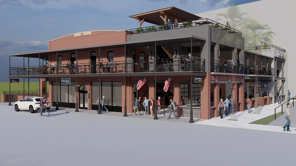 Multi-level building with brick façade, balcony, outdoor seating, and American flags.