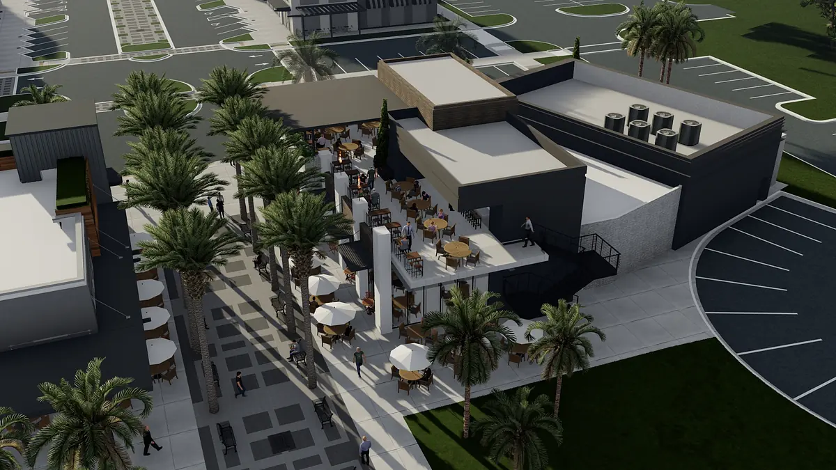 Outdoor dining area with tables, umbrellas, palm trees, and a paved walkway.