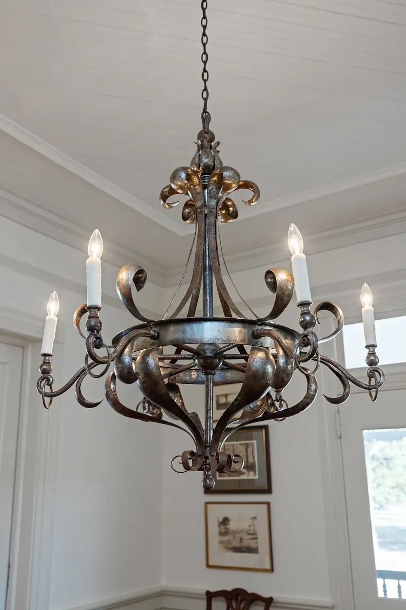 Room with decorative chandelier and framed artwork on walls.
