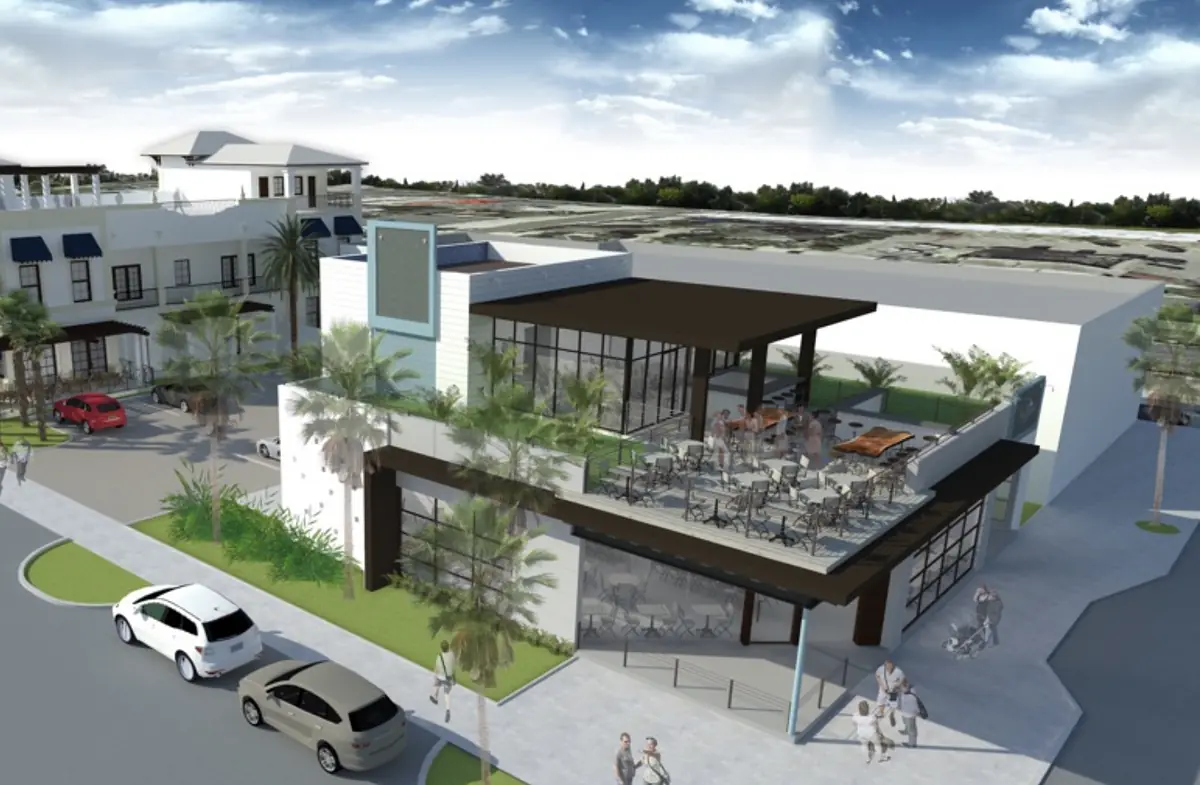 Exterior view of a commercial building with patio seating, palm trees, and vehicles.