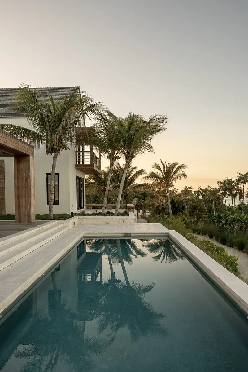 Exterior rear with swimming pool, landscaped garden, palm trees, and multi-story house.