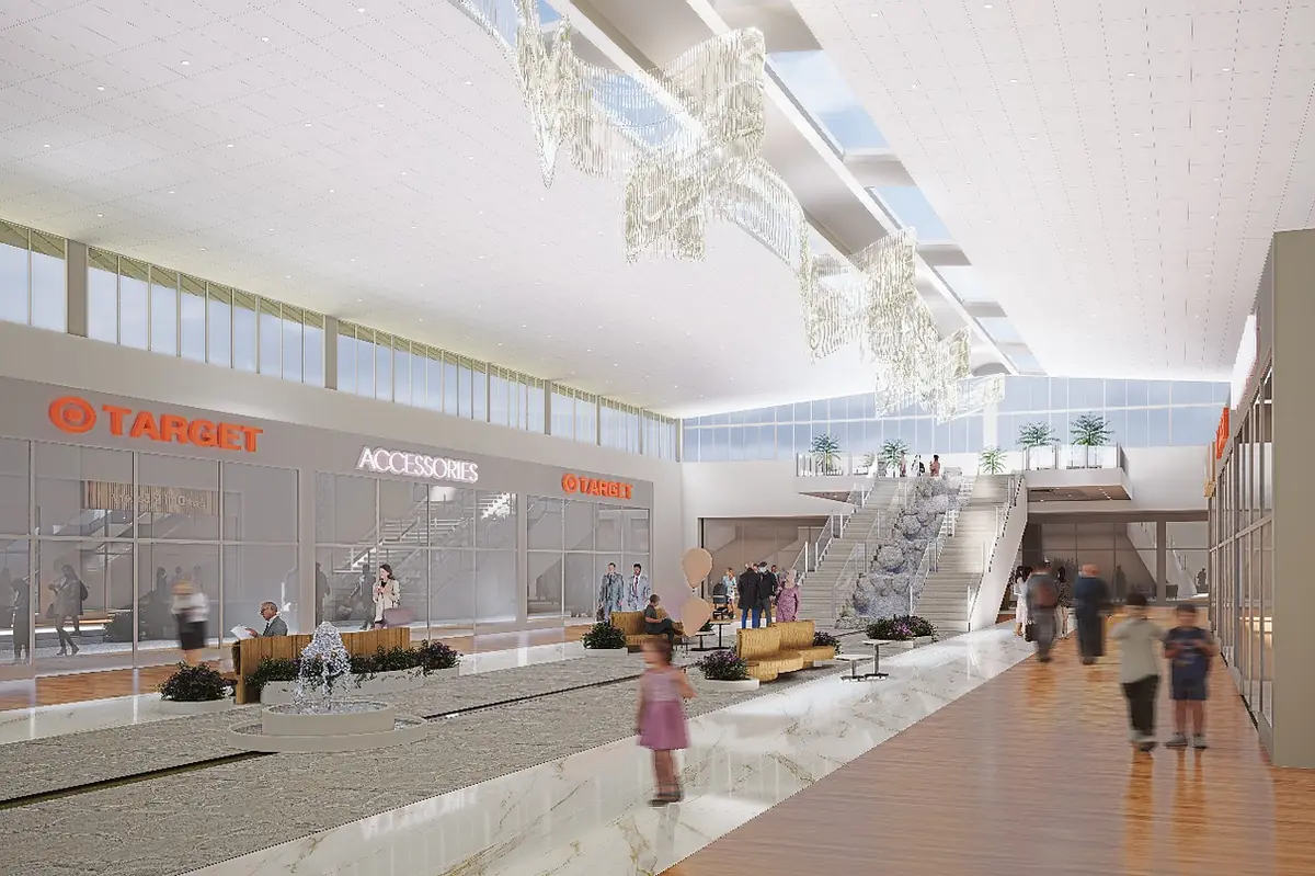 Open commercial space with store fronts, seating areas, water feature, and large windows.