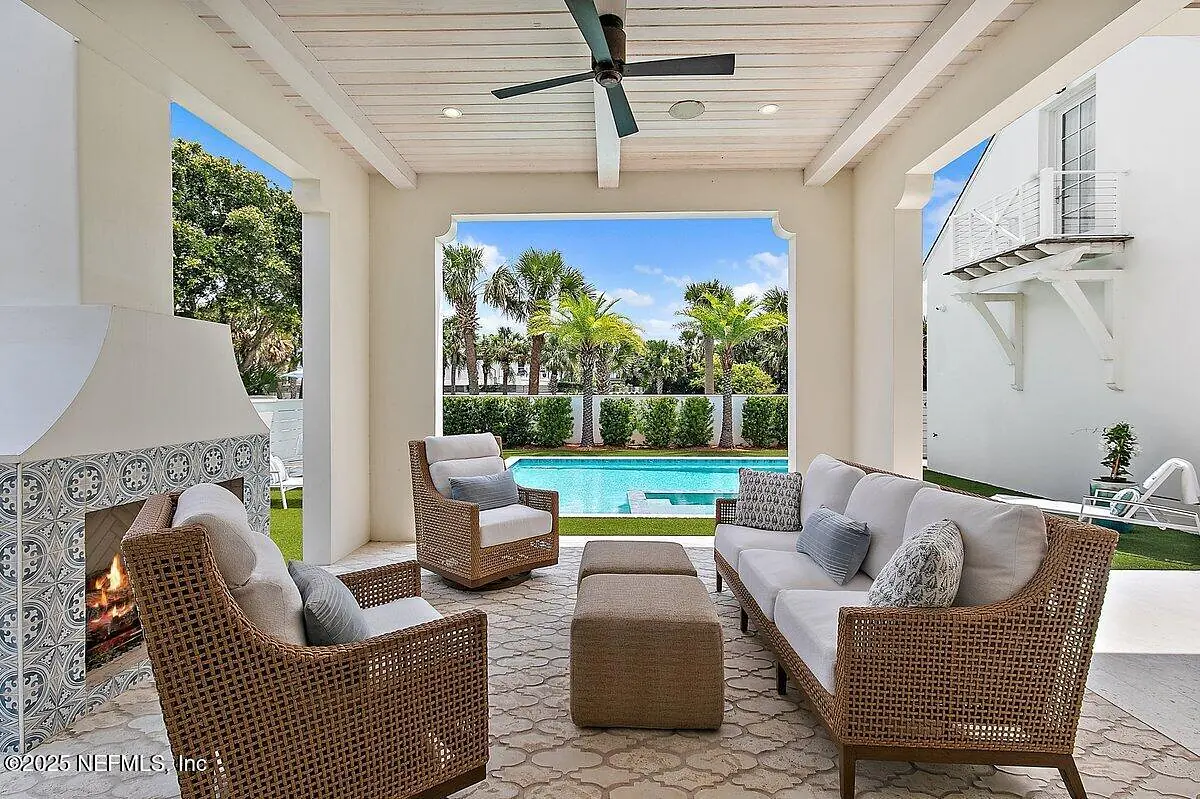 Patio with sectional sofa, woven coffee table, area rug, ceiling fan, and views of swimming pool and palm trees