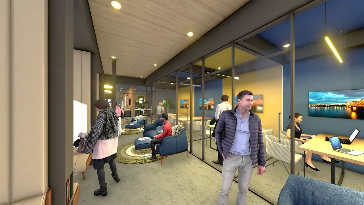 Office area with blue chairs, desk, laptop, glass walls, and people working with artwork on the walls.