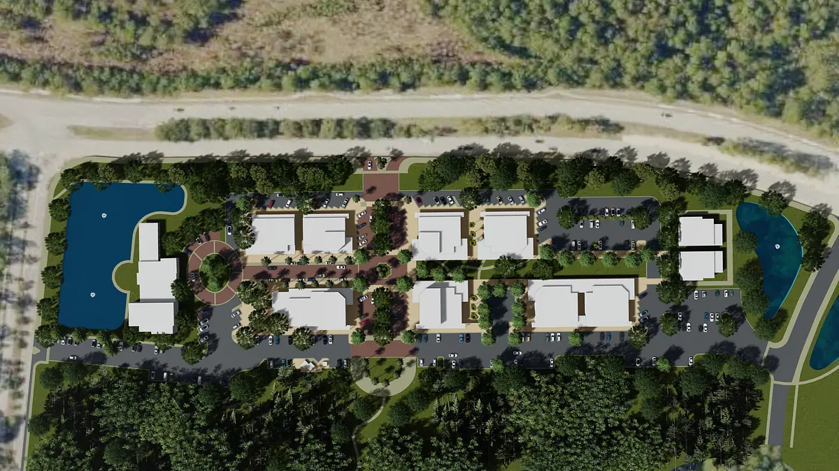 Aerial view of buildings, parking, pathways, trees, and a nearby lake.