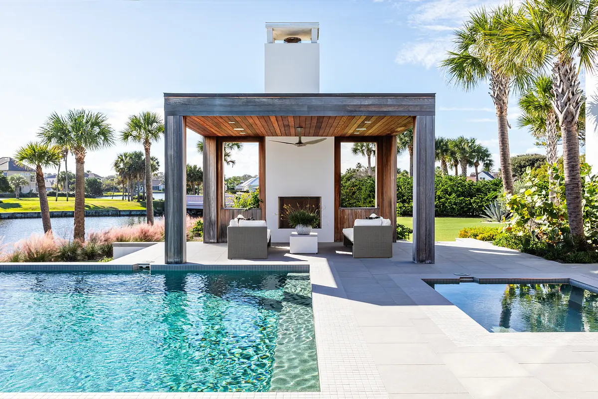 Outdoor patio with swimming pool, hot tub, shaded seating area, and palm trees.