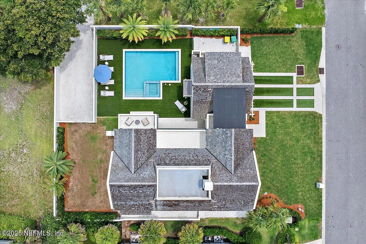 Aerial view of exterior with swimming pool, patio, and palm trees.