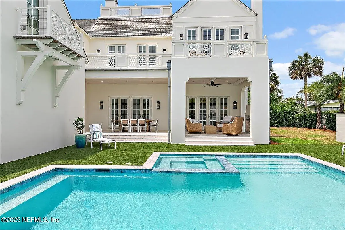 Exterior rear with swimming pool, patio area, sliding doors, and lush green grass.