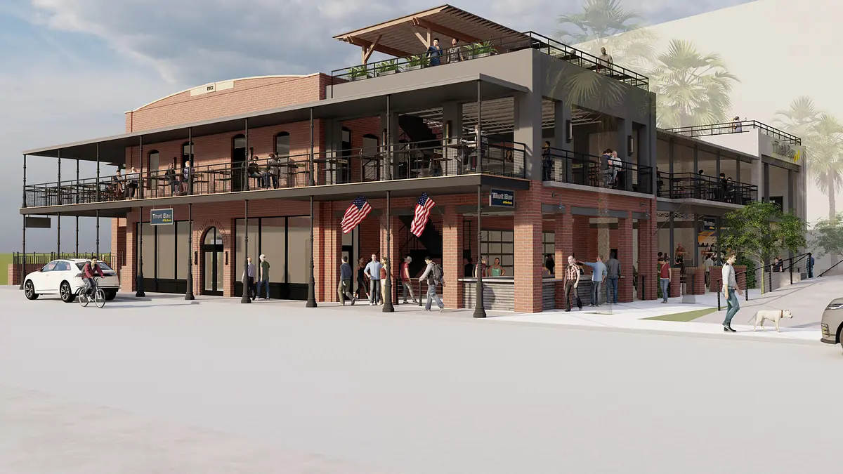 Exterior front view of a multi-level building with brick facade, balconies, outdoor seating, and palm trees.