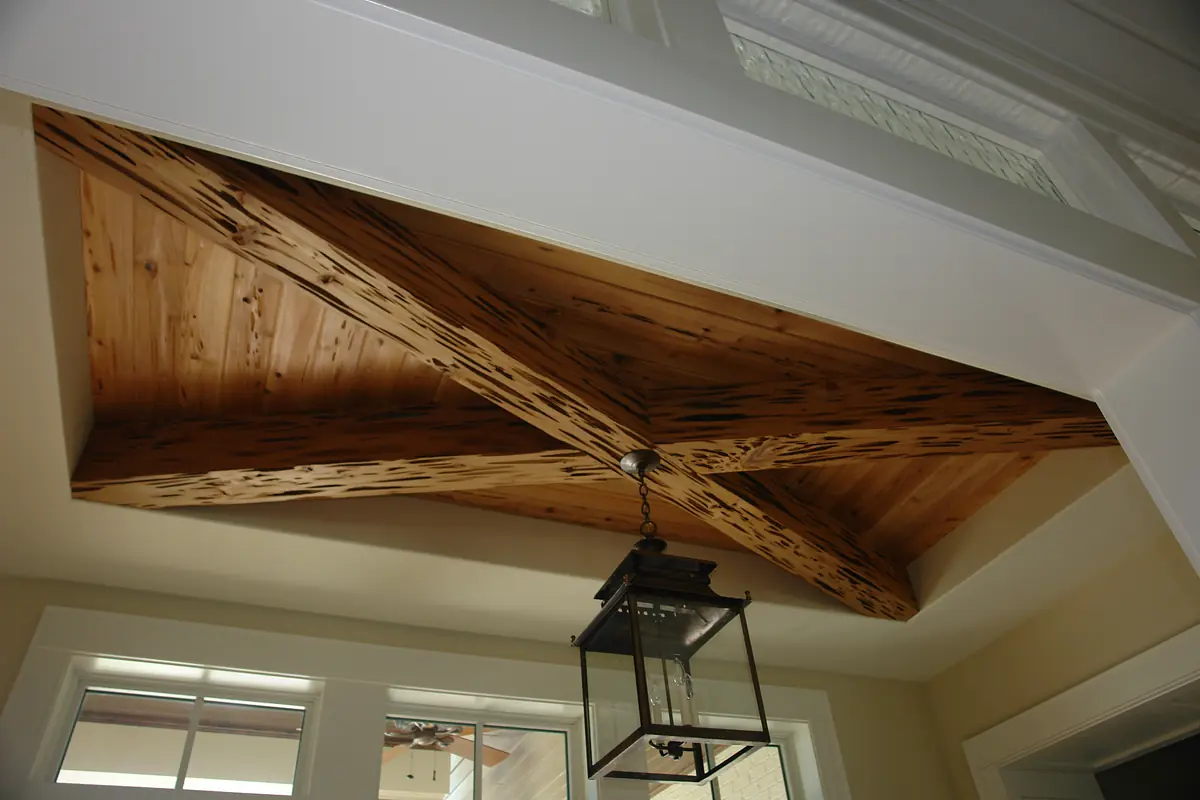 Foyer with vaulted ceiling, wooden beams, decorative lantern, and large windows for natural light.