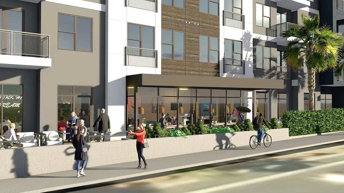 Exterior view of a building with large windows, wooden wall, outdoor seating, and visible pedestrians.